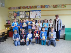 Die Kinder halten ihr Buchgeschenk in den Händen